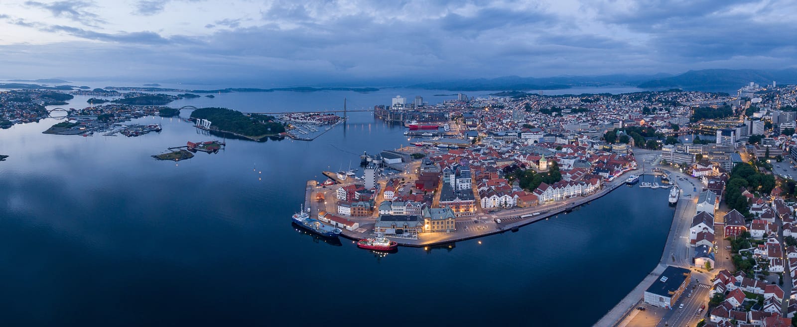 Stavanger sentrum og Vågen sett fra luften i blåtimen, med bybroen og øyene i Byfjorden bak